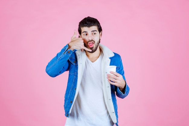 Homme avec une tasse de café demandant un appel