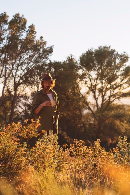 Homme avec une tasse dans la nature