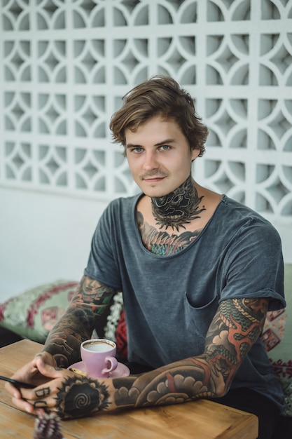 Photo gratuite homme tatoué, boire du café dans un café