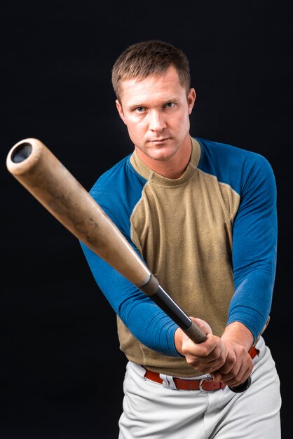 Homme tenant une batte de baseball et posant
