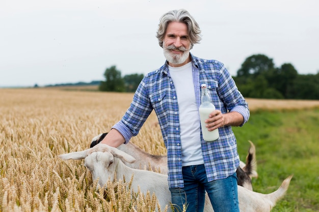 Homme tenant une bouteille de lait de chèvre