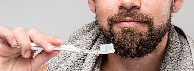 Photo gratuite homme tenant une brosse à dents close-up