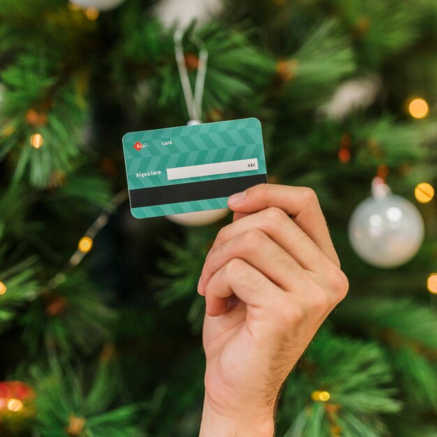 Homme tenant une carte de crédit en plastique à la main