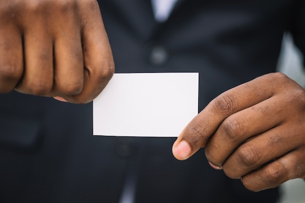 Homme tenant une carte de visite dans les deux mains