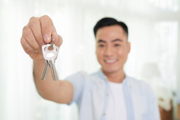 Homme tenant la clé du nouvel appartement