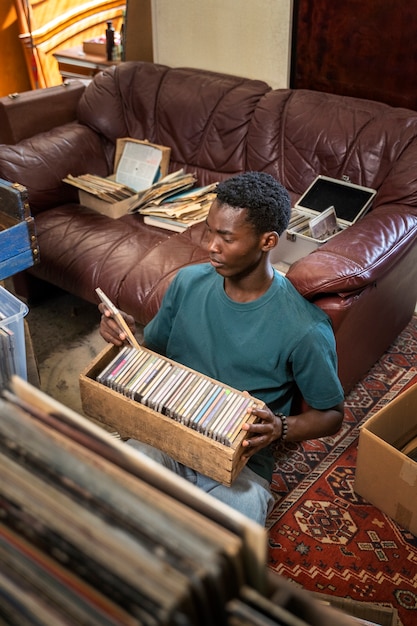 Homme tenant des disques vinyles grand angle
