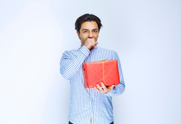 Homme tenant ou offrant une boîte cadeau rouge à sa petite amie. photo de haute qualité