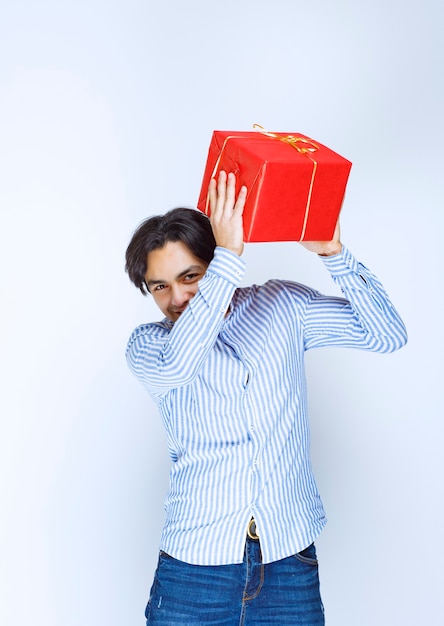 Homme tenant ou offrant une boîte cadeau rouge à sa petite amie. photo de haute qualité