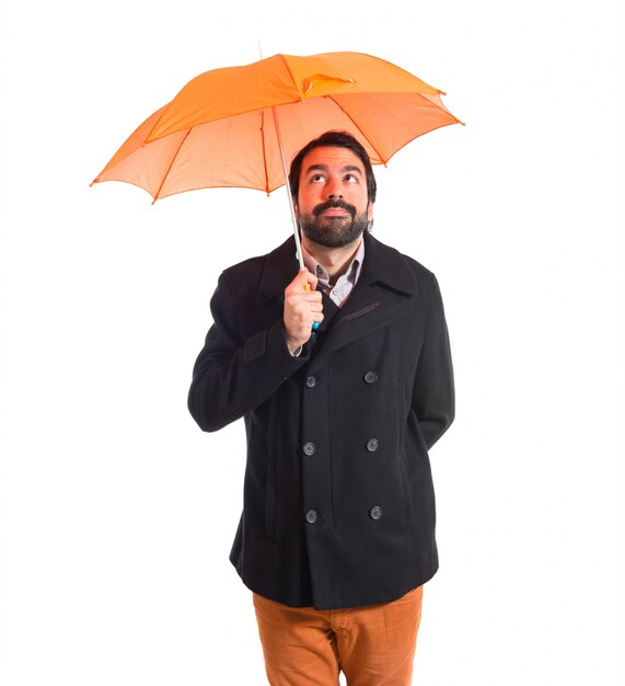 Homme tenant un parapluie sur fond blanc