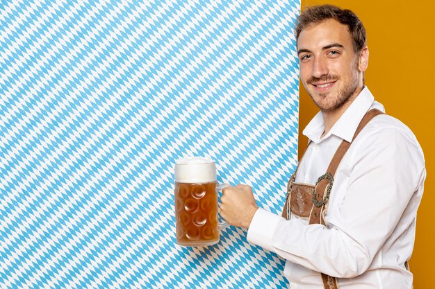 Homme tenant une pinte de bière et fond à motifs