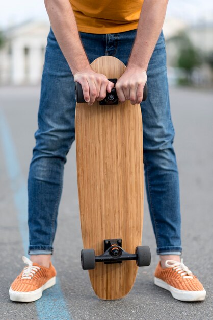 Homme tenant une planche à roulettes