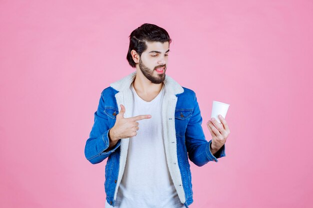 Homme tenant et présentant une nouvelle tasse de café jetable