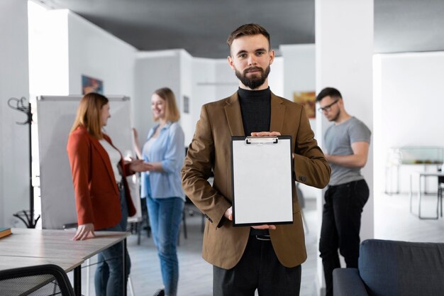 Homme tenant un presse-papiers au travail