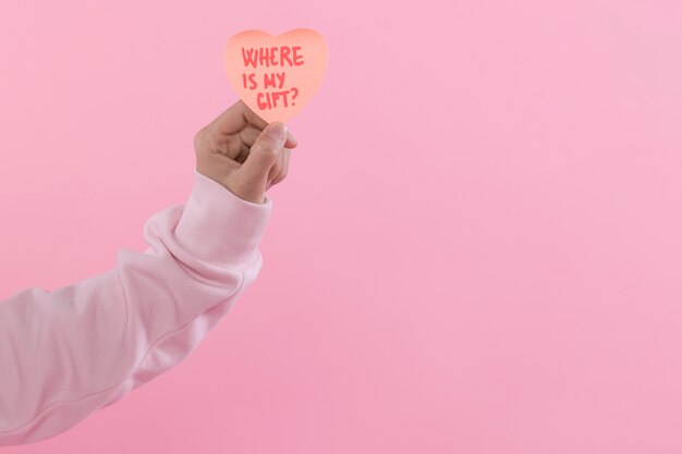 Homme tenant un symbole décoratif en papier du coeur