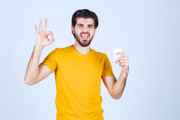 Homme tenant une tasse de café et appréciant le goût.