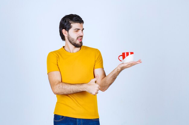 Homme tenant une tasse de café et appréciant le goût.