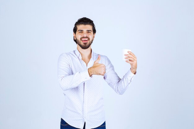 Homme tenant une tasse de café et apprécié le goût