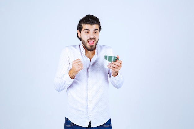 Homme tenant une tasse de café et se sentant puissant