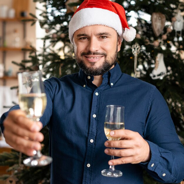 Photo gratuite homme tenant des verres de champagne à noël