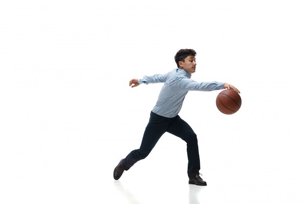 Homme en tenue de bureau jouant au basket sur un espace blanc. Look inhabituel pour homme d'affaires en mouvement, action. Sport, mode de vie sain.