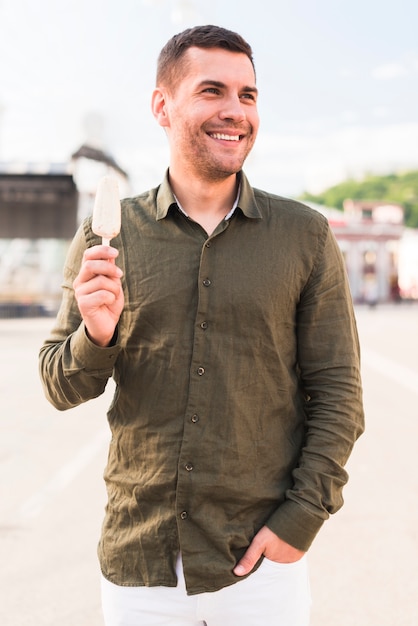 Homme, tenue, popsicle, regarder loin, et, sourire