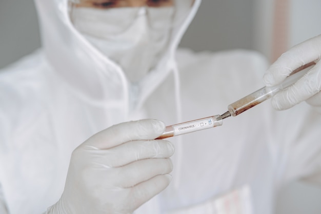 Homme en tenue de protection et lunettes travaillant au laboratoire