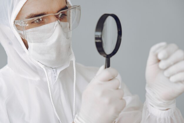 Homme en tenue de protection et lunettes travaillant au laboratoire