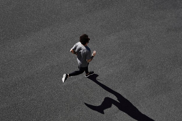 Homme en tenue de sport en cours d'exécution sur route