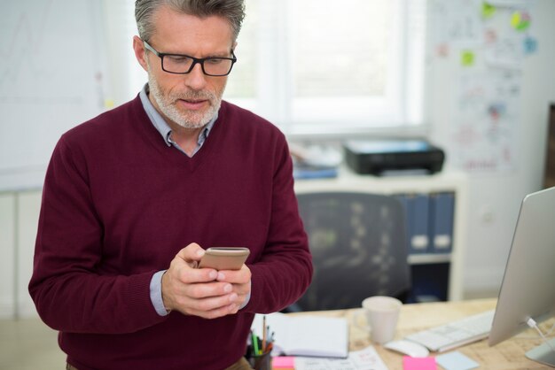 Homme textos pendant son travail au bureau