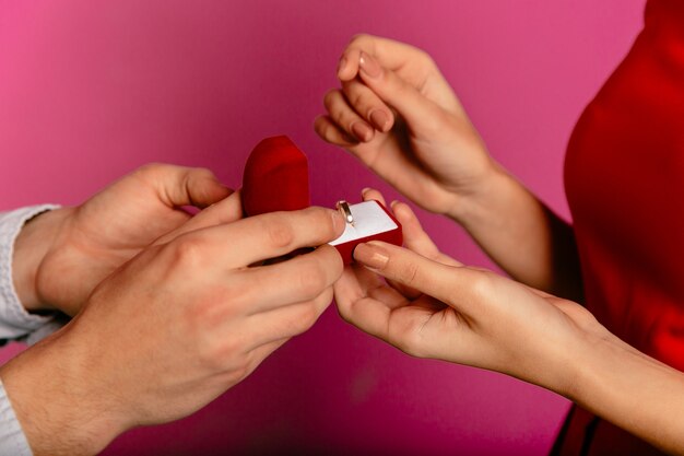 Homme tient une boîte cadeau avec une bague de fiançailles, va faire une proposition à sa petite amie