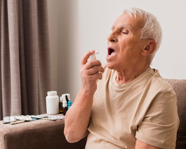 Photo gratuite homme de tir moyen à l'aide d'un spray oral