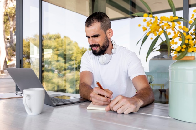 Homme de tir moyen prenant des notes