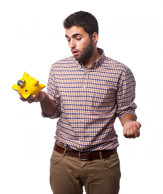 Photo gratuite l'homme avec une tirelire jaune