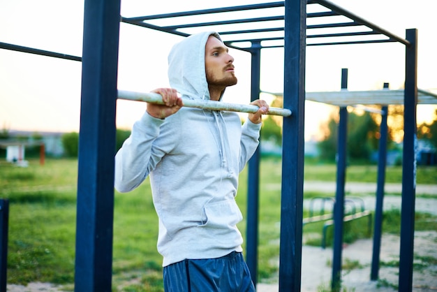 Photo gratuite l'homme avec un tonifiant de capot dans le parc