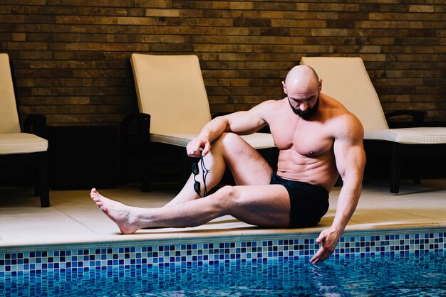 Homme touchant l&#39;eau de la piscine