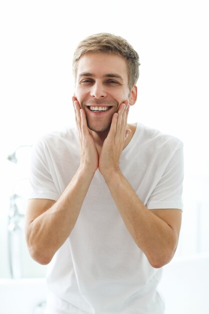 Homme touchant sa barbe, prêt à se raser.