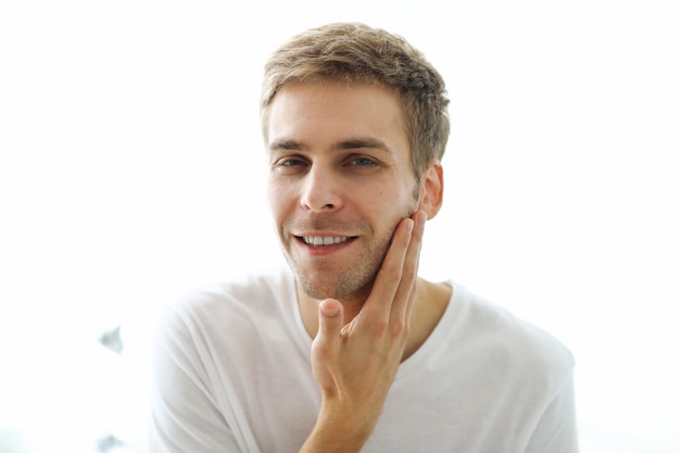 Homme touchant sa barbe, prêt à se raser.