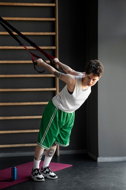 Photo gratuite homme trans travaillant et faisant de l'exercice à la salle de sport