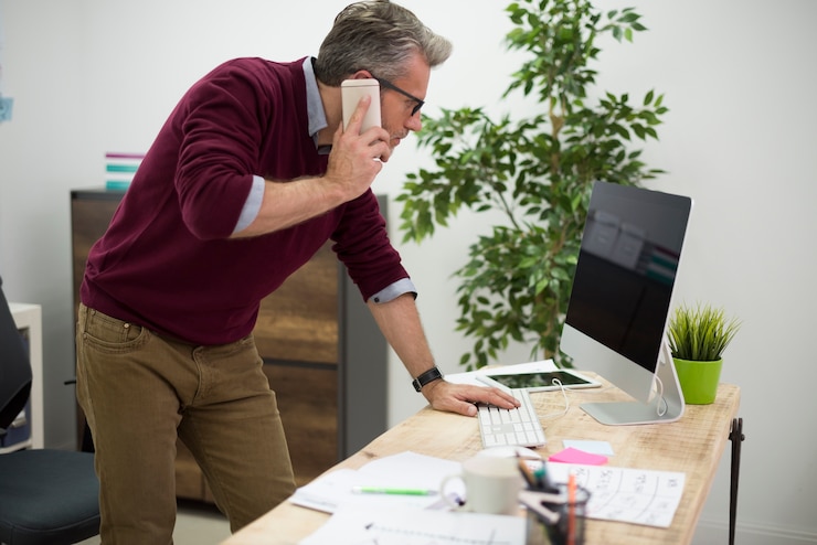 Photo gratuit homme de travail se penchant sur le bureau