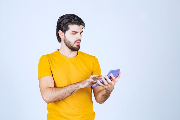 Homme travaillant avec une calculatrice et pensant.