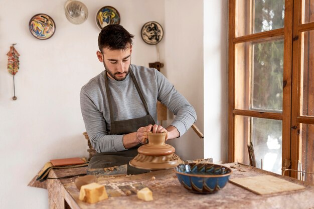 Homme travaillant dans l'atelier de poterie