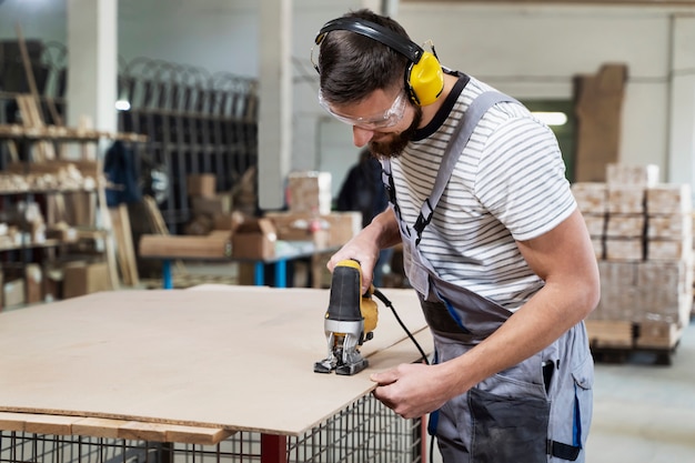 Homme travaillant sur la découpe de panneaux mdf