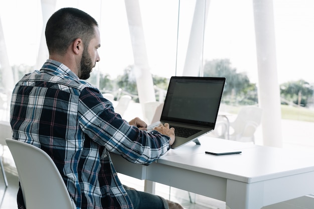 Homme travaillant devant l'ordinateur portable dans un espace de travail