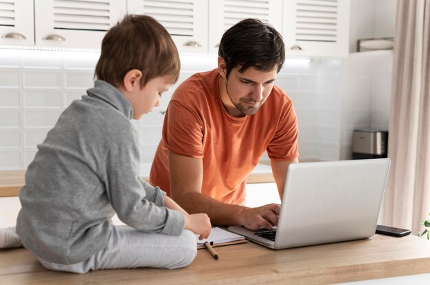 Homme travaillant à distance avec kid shot moyen