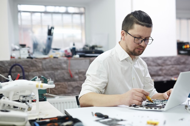 Homme travaillant avec l'électronique