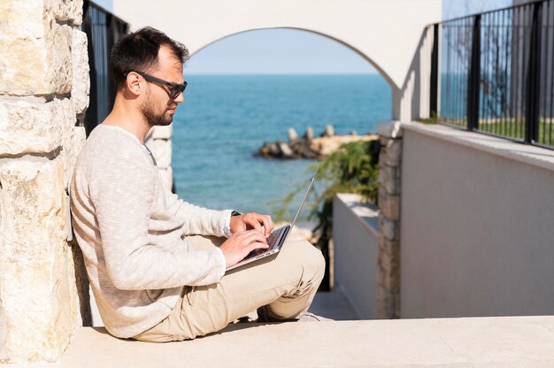 Photo gratuite homme travaillant à l'extérieur près de la plage