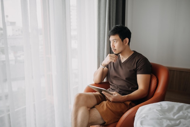Homme travaillant avec sa tablette numérique à l'hôtel dans le concept de travail