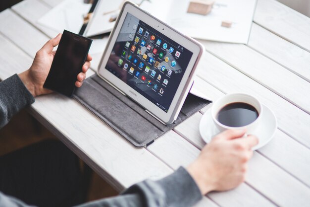 Homme travaillant avec une tablette et mobiles