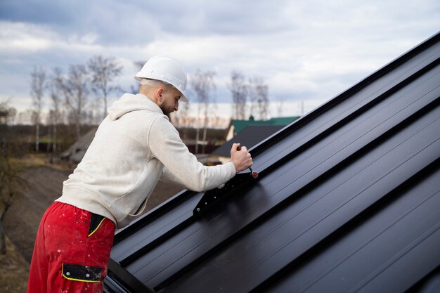 Homme travaillant sur le toit moyen tiré