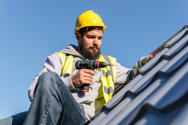 Photo gratuite homme travaillant sur la vue de face du toit